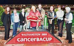 Race 7  ‘The Ian Dury Memorial Stakes’ CancerBACUP Chief Executive, Joanne Rule and reporter, Liz Bestic present the winning trophy